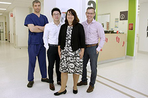 A woman and three men who are members of the FSFHG Multidisciplinary Diabetic Foot Unit stand inside a hospital treatment area.