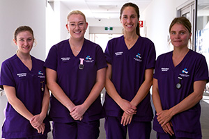 Four female graduate midwives standing side-by-side 
