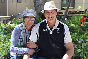 A woman and man sit side by side in a garden