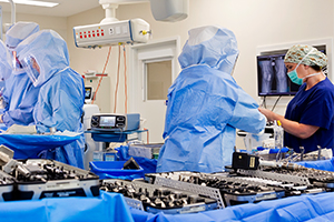 Four staff in surgical scrubs working in an operating theatre