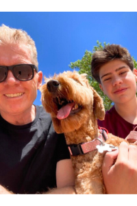 Nick on the left wearing sunglasses taking a selfie with his dog in the middle and son on the right.