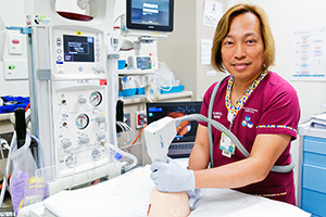 A male clinical nurse demonstrates how to use an item of medical equipment.