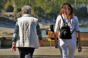 Two woman walking outside towards a lake