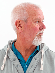 A man stands with his head turned to his left