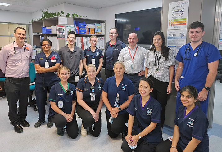 A group of male and female health professionals stand in a treatment area