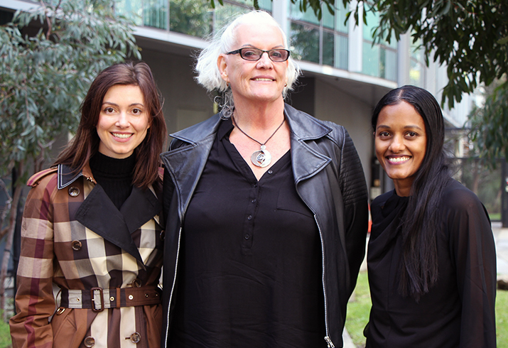 Three women who are part of SurgFit School team stand together outside smiling.