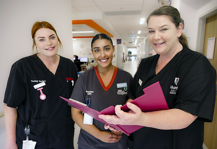 Two female Murdoch University nursing students stand either side a Fiona Stanley Hospital female Registered Nurse.