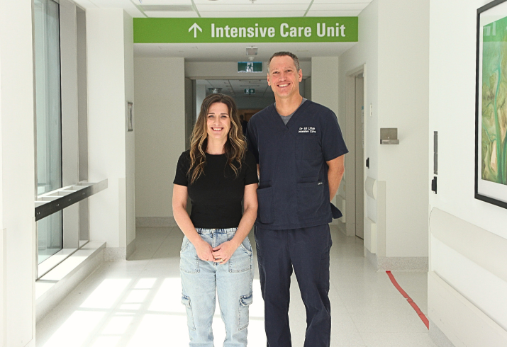 Former patient Kylie Dibb and FSH ICU Consultant Dr Ed Litton standing next to each other in a hallway, in front of an ICU sign.