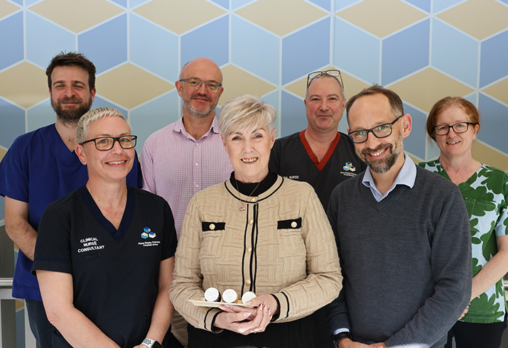 Julie pictured front centre, standing with the clinicians involved in her cancer journey.