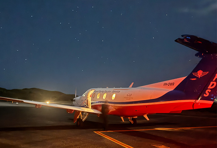 A Royal Flying Doctor Service plane on the tarmac at Rottnest Island underneath a starry sky
